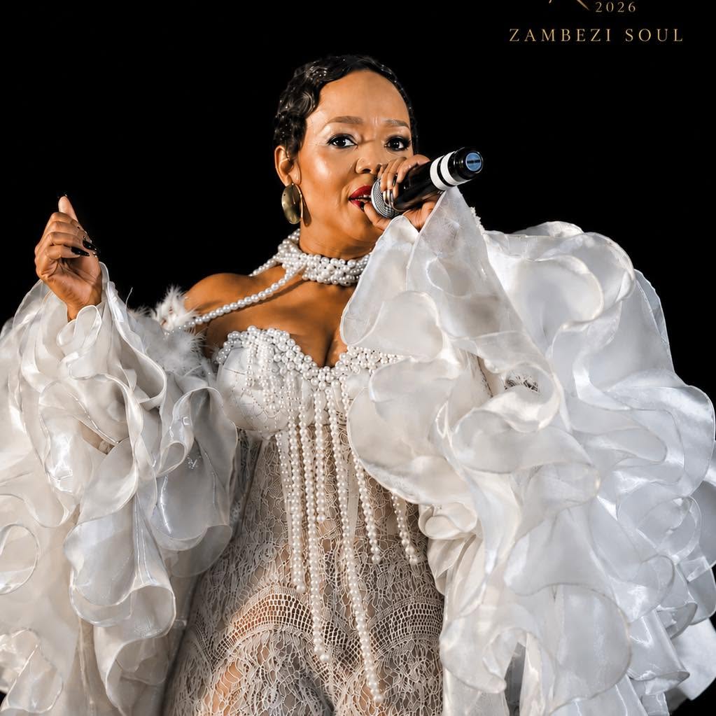 Kearoma Rantao performing in a white pearl-trimmed gown, singing into a microphone